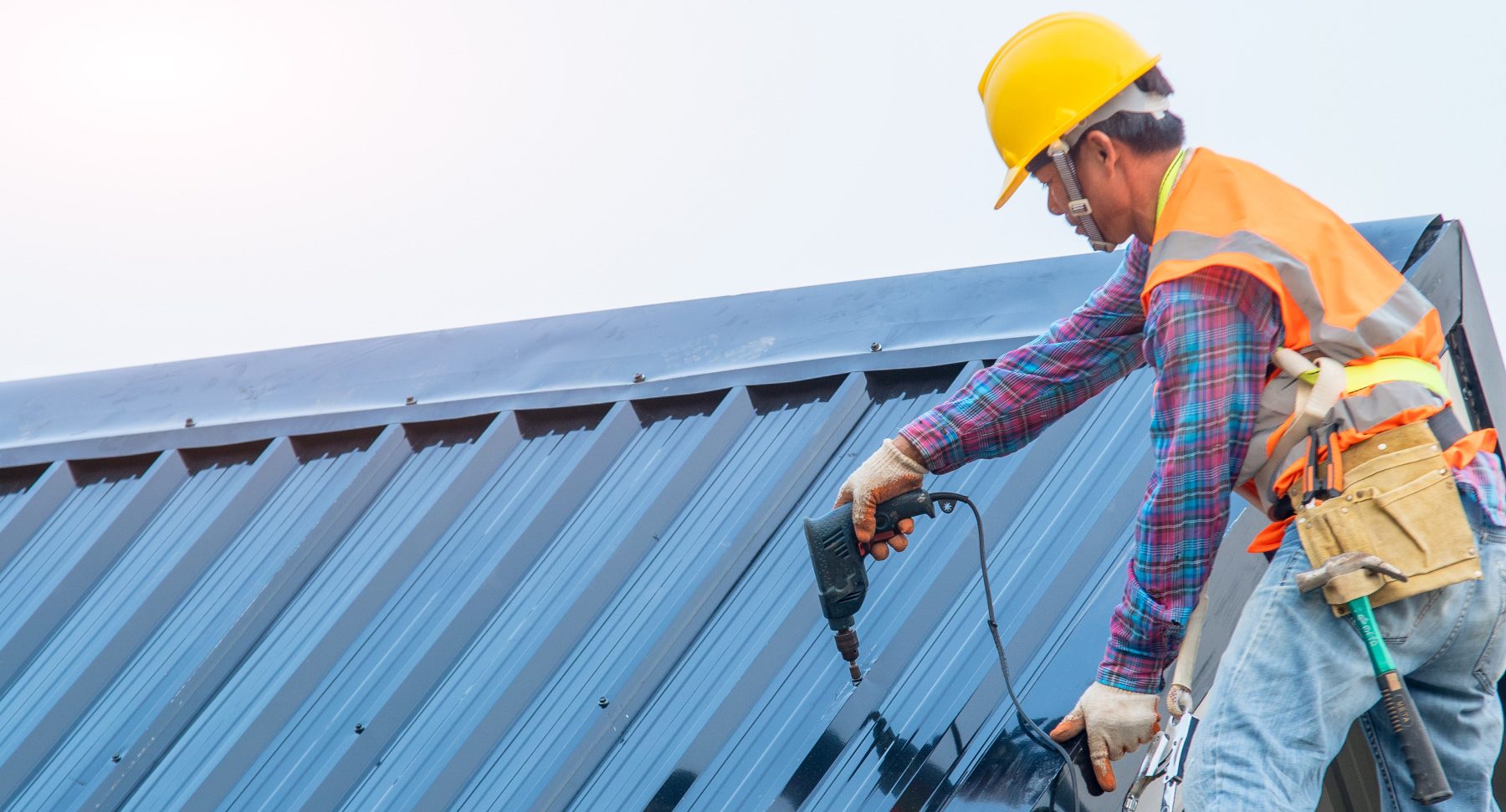 A contractor installing a metal roof on a residential building. 